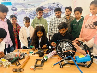 Learners examining an electric vehicle motor and components
