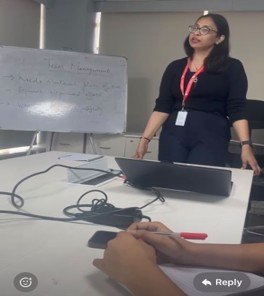 Trainer guiding a classroom session beside a whiteboard